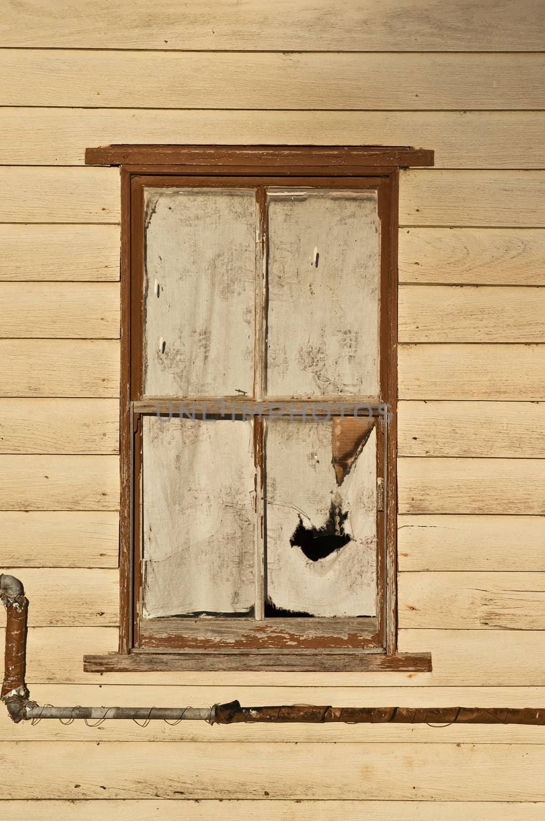 old window with torn curtain in this deserted house