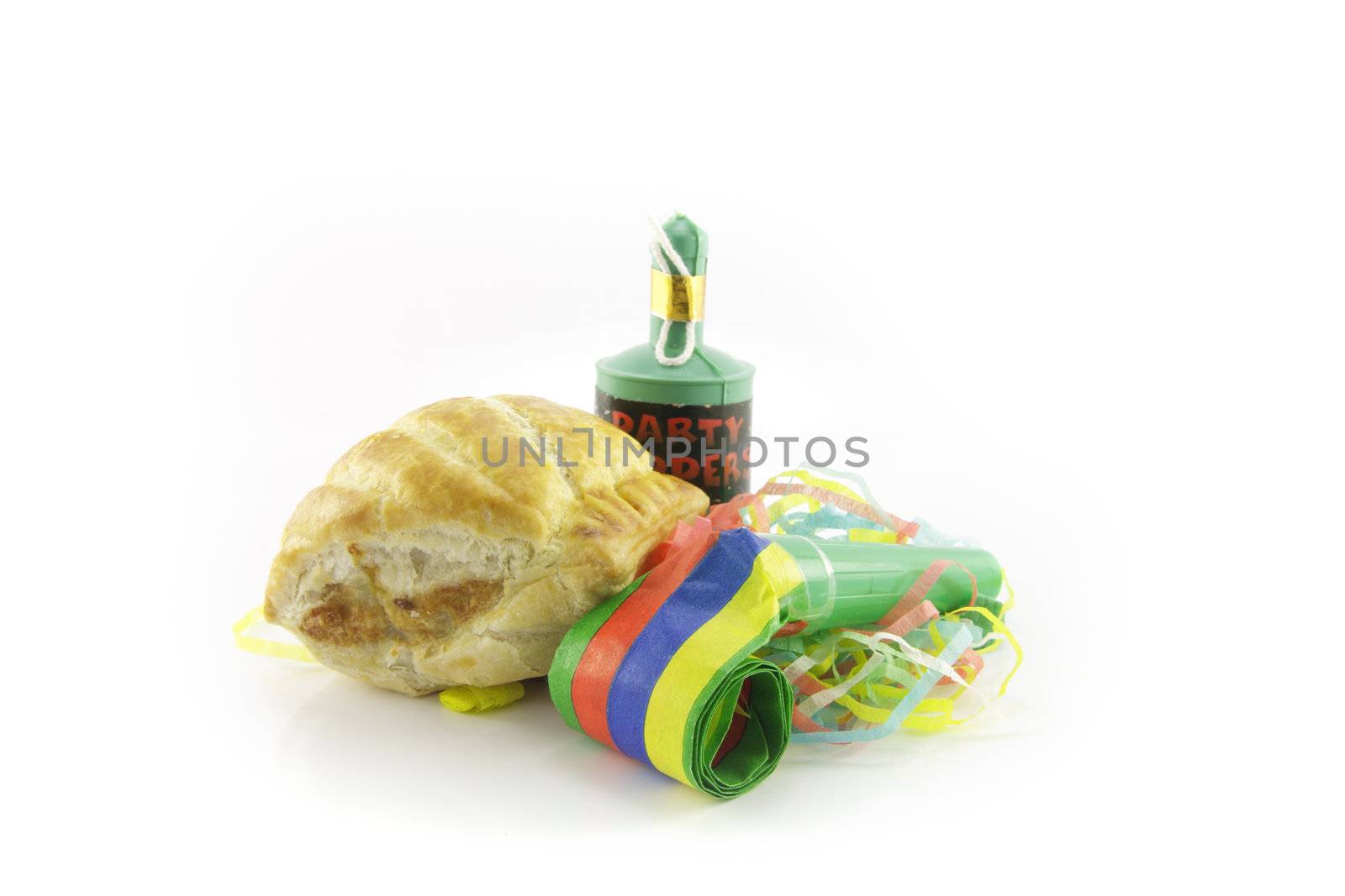 Small tasty sausage roll with party blower and party popper with streamers on a reflective white background