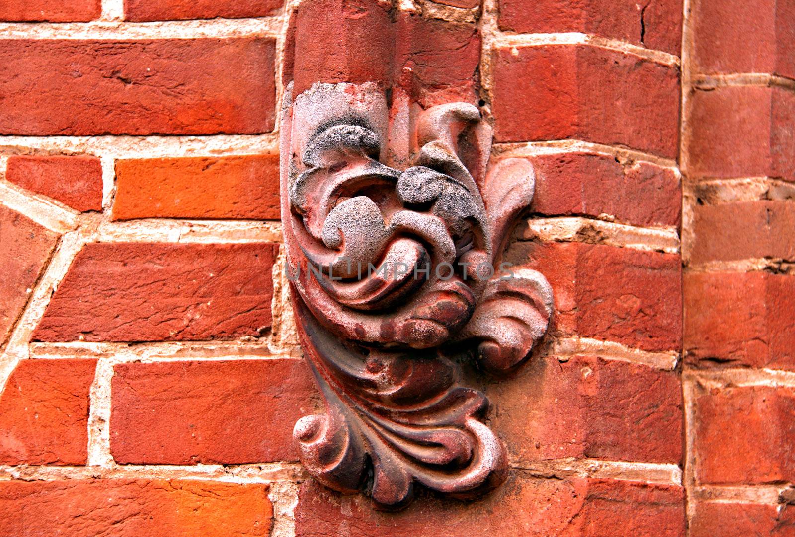 Ornate Decorations on Exterior Red Brick Wall by Cloudia