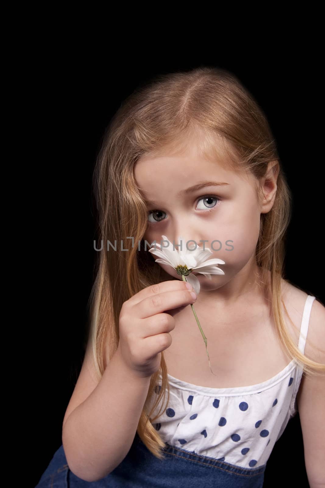 Pretty blue eyed girl smelling white flower