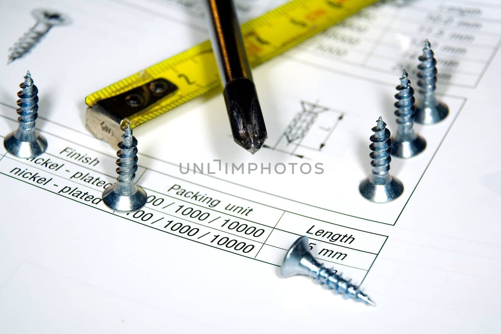 Screwdriver, screws and the drawing on a work desktop