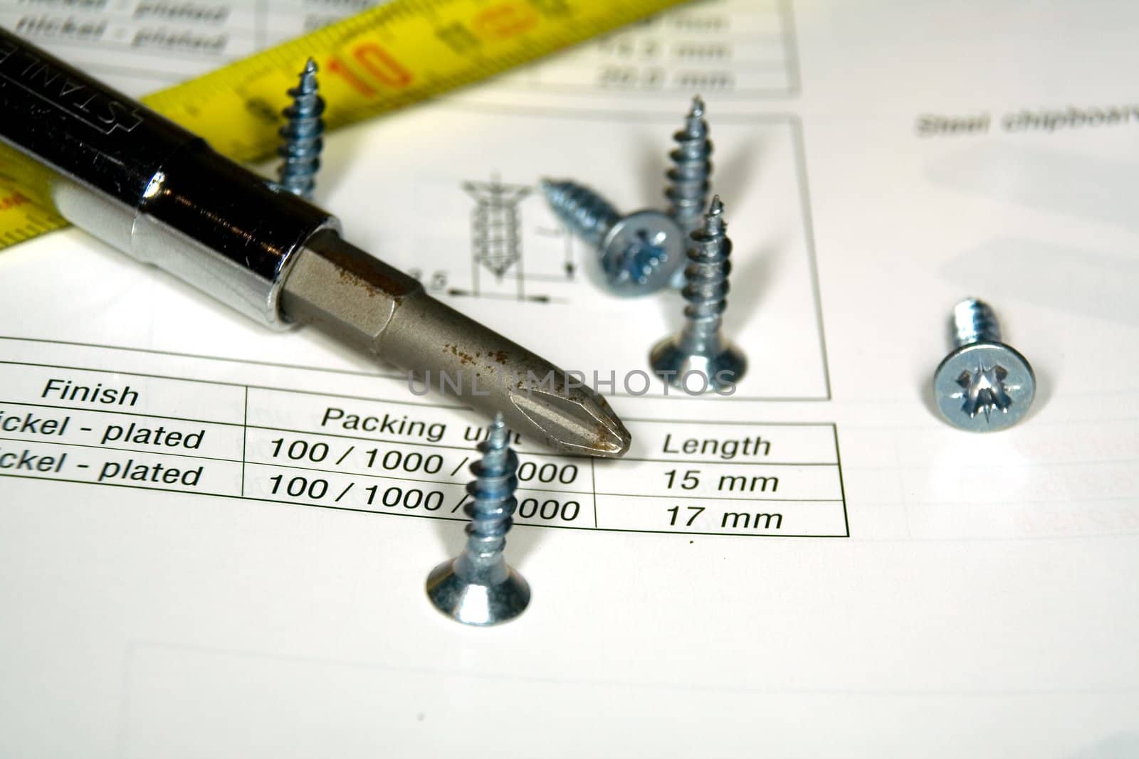 Screwdriver, screws and the drawing on a work desktop