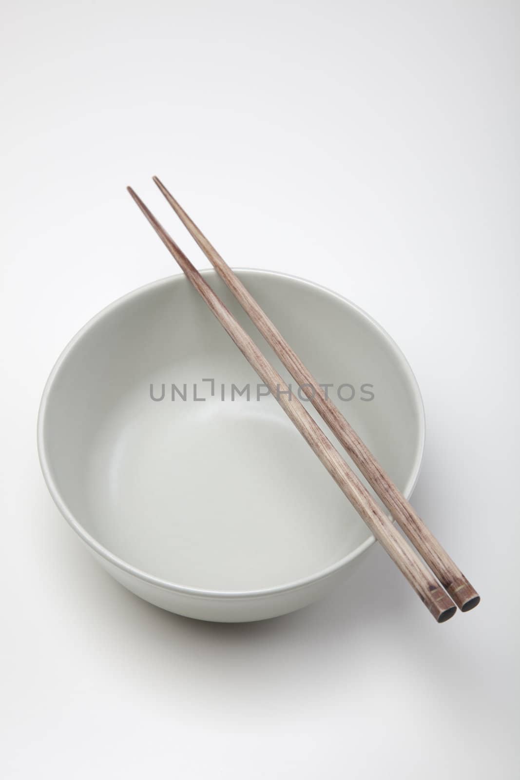 Closeup of chopsticks resting on a bowl