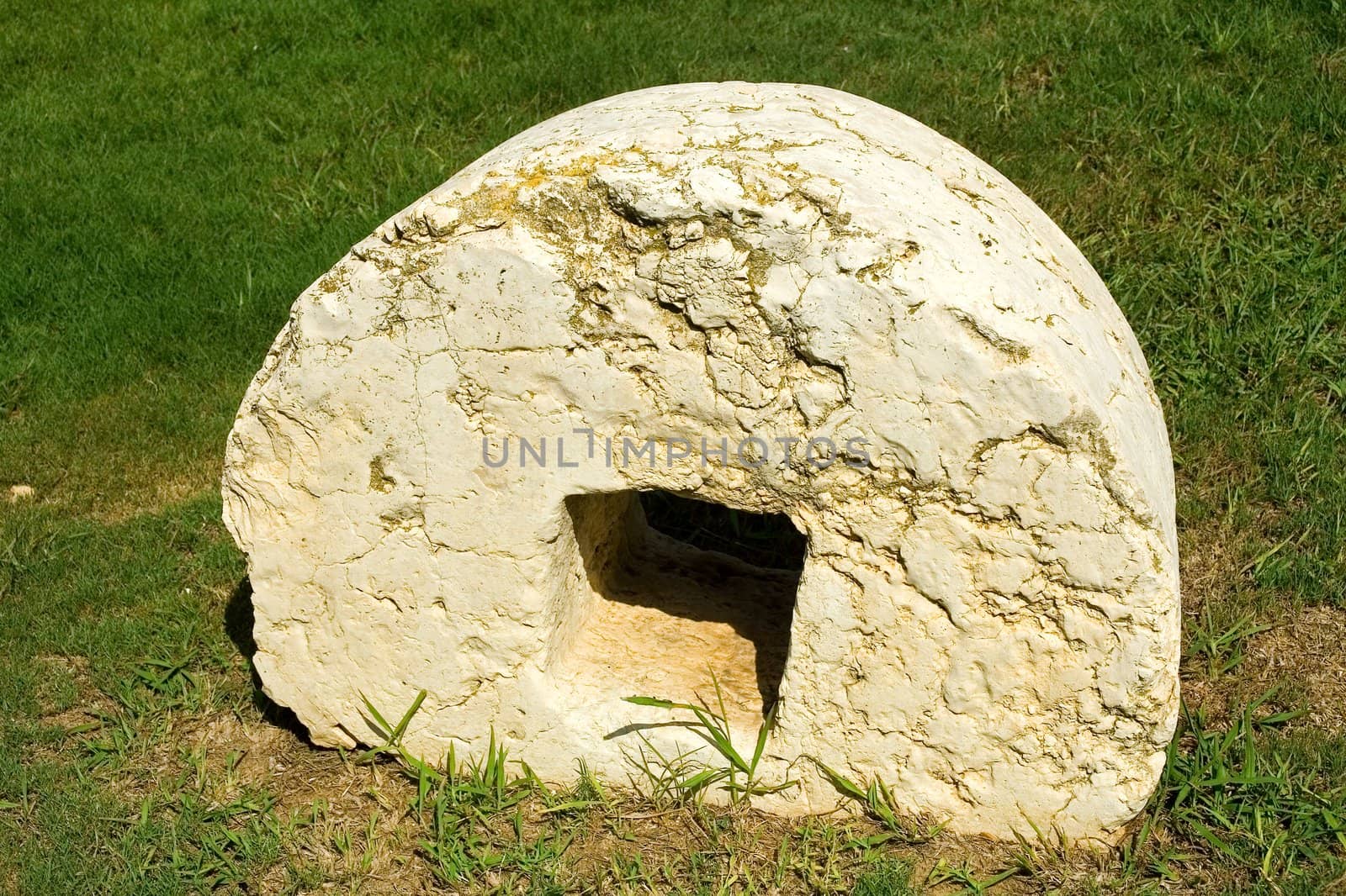 An ancient millstone were located on the grass in the natural background