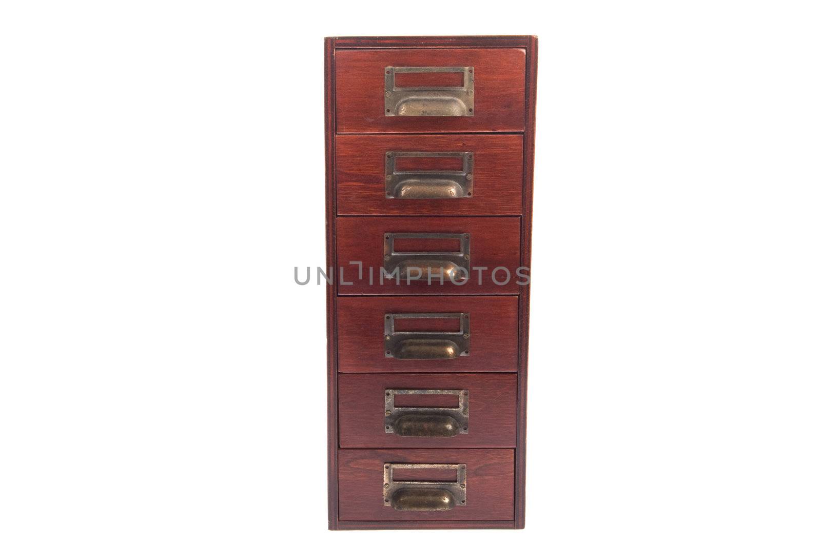 Antique six drawer oak library file card cabinet with brass label holders isolated over white background.