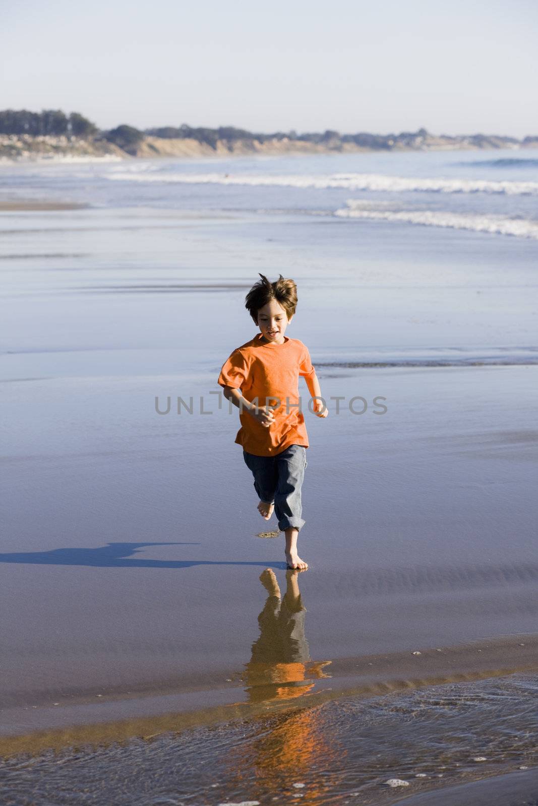 Little Boy Running Barefoot on The Sand at the Beach