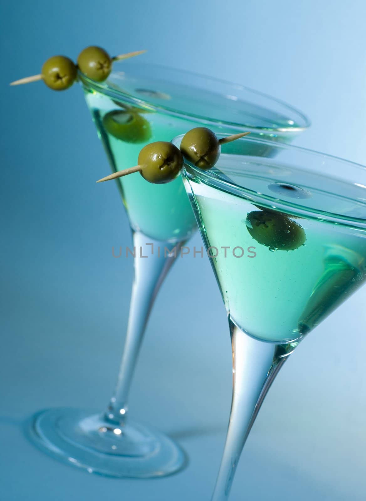Martini cocktail with olives and blue background