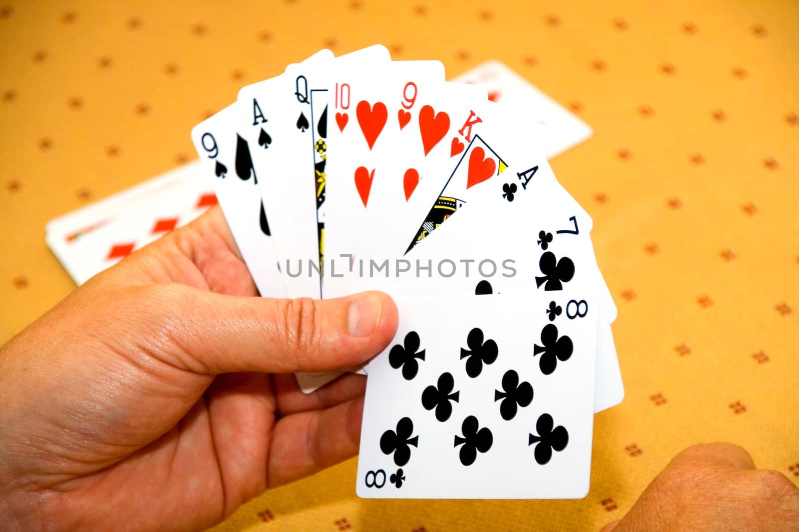 Hands of the player with playing cards on a game table