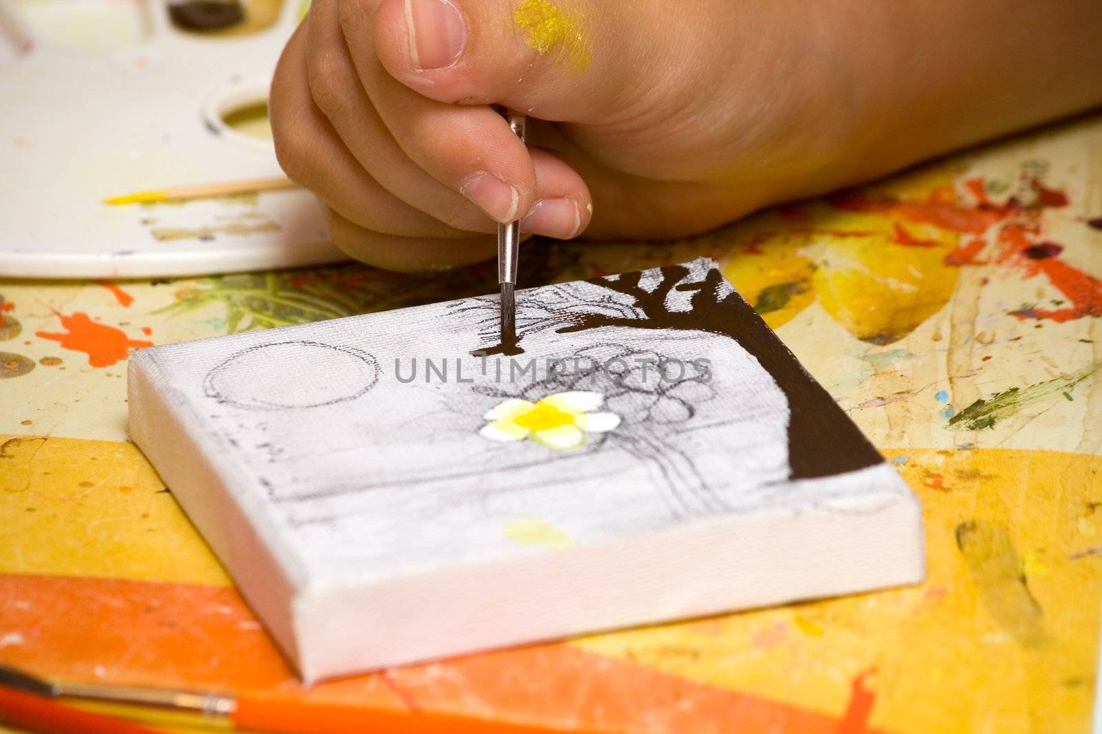 Hands of the young artist of the miniature painter drawing a picture.Work of the artist.