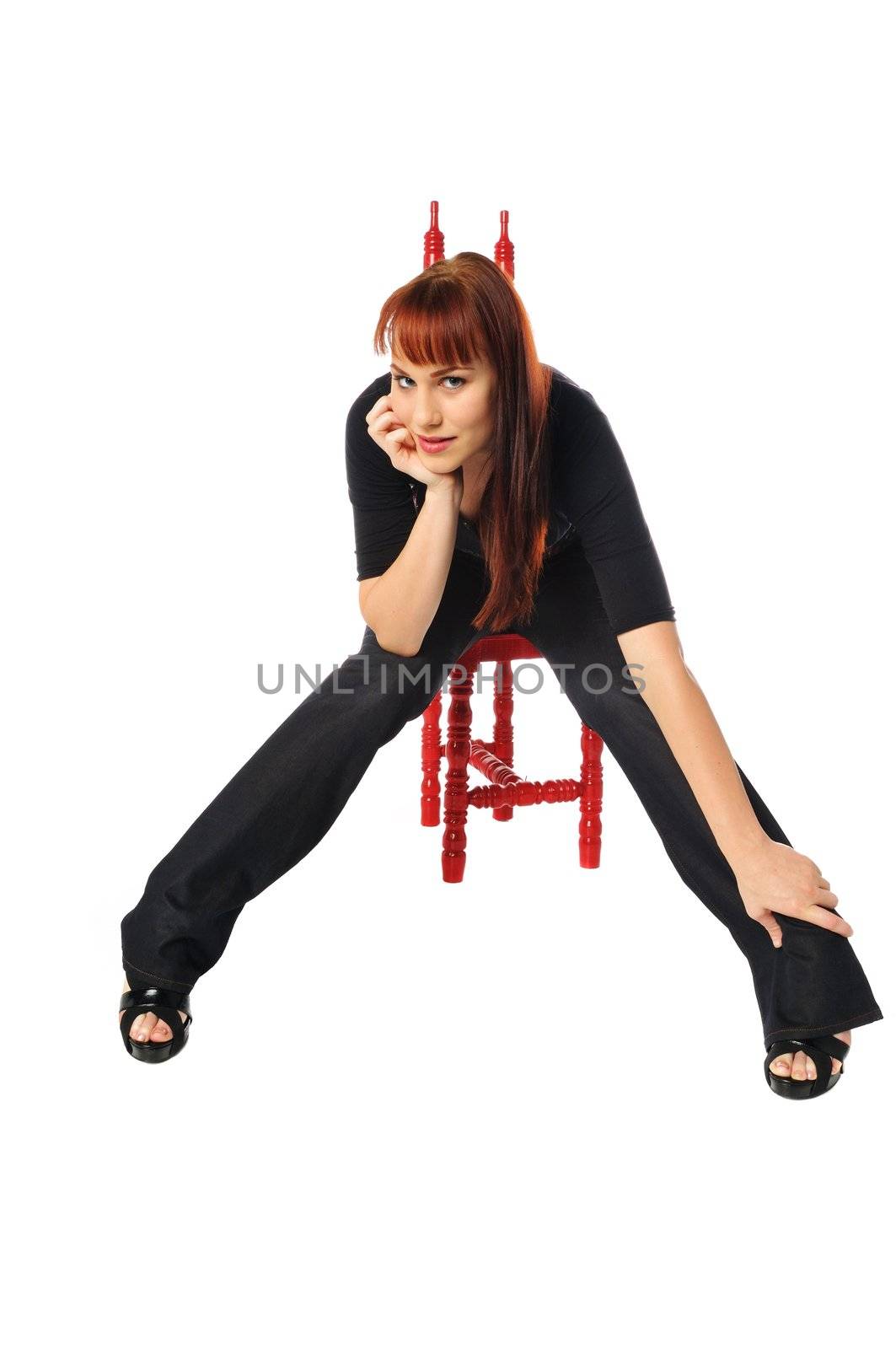 attractive young redhead sitting in a chair on a white background