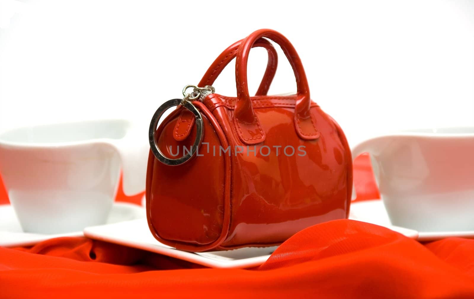 Red elegant female handbag the beautician on a red fabric among white ware