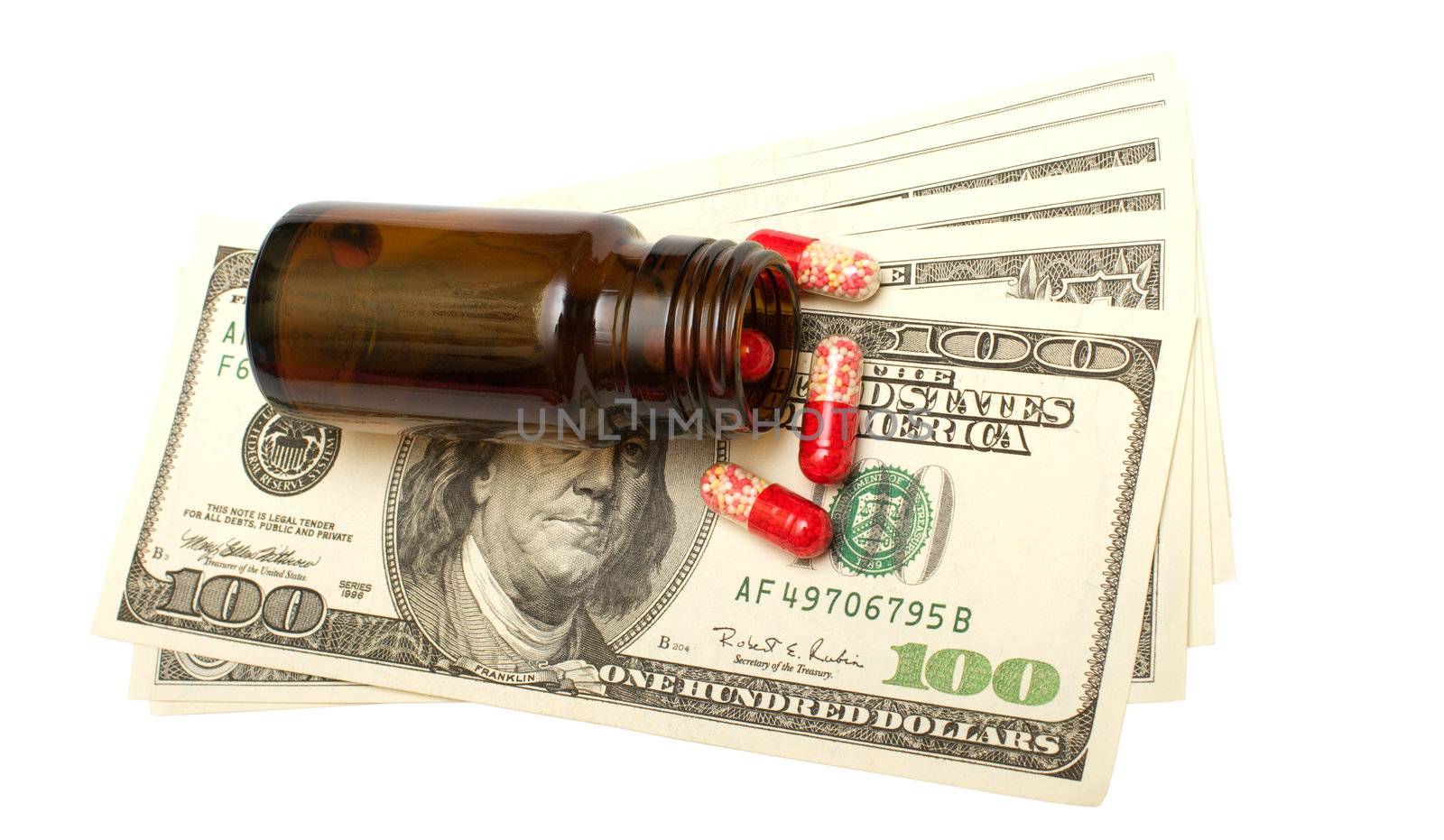 Bottle with pills on dollars it is isolated on a white background.