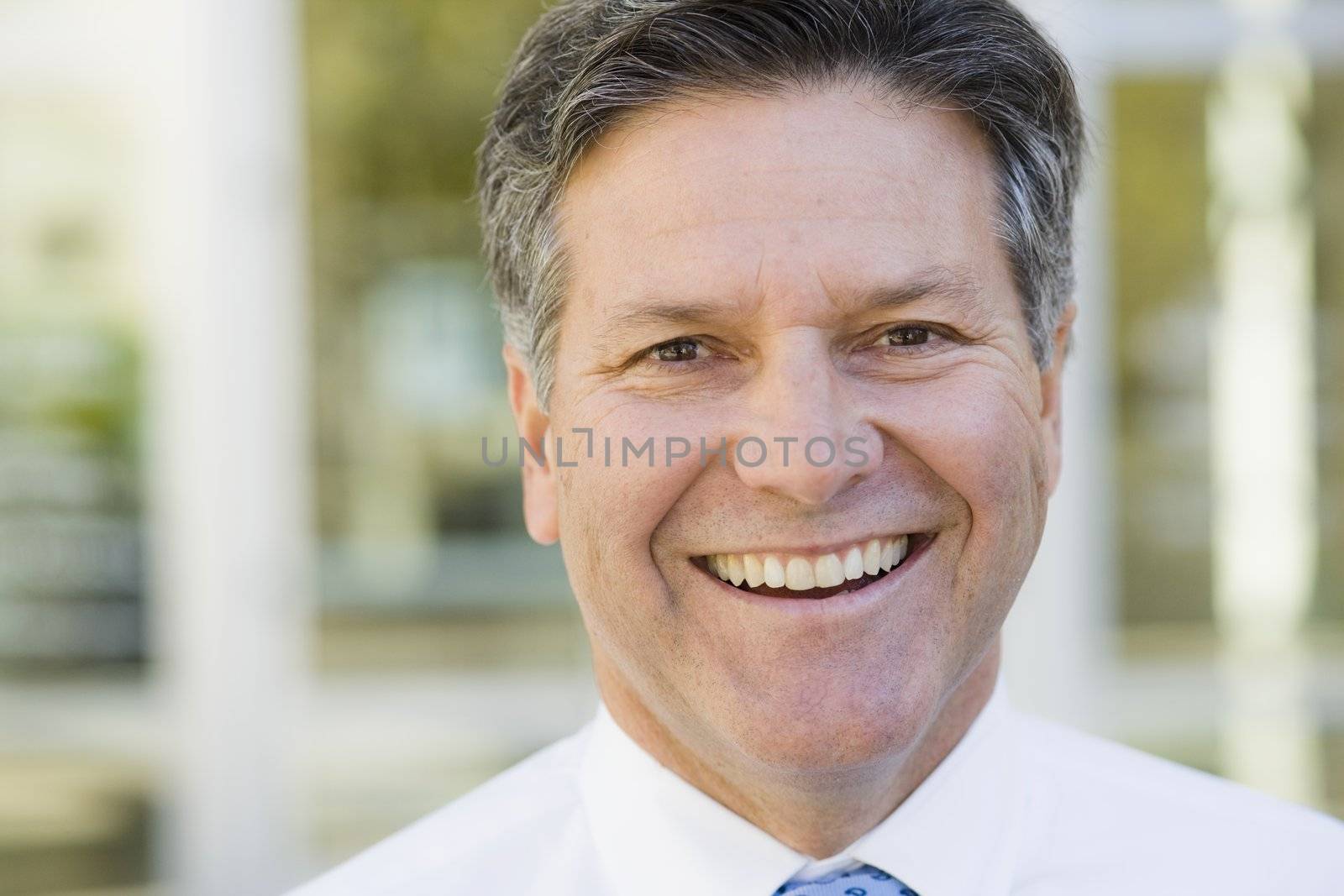 Portrait of a Smiling Businessman Standing Outdoors