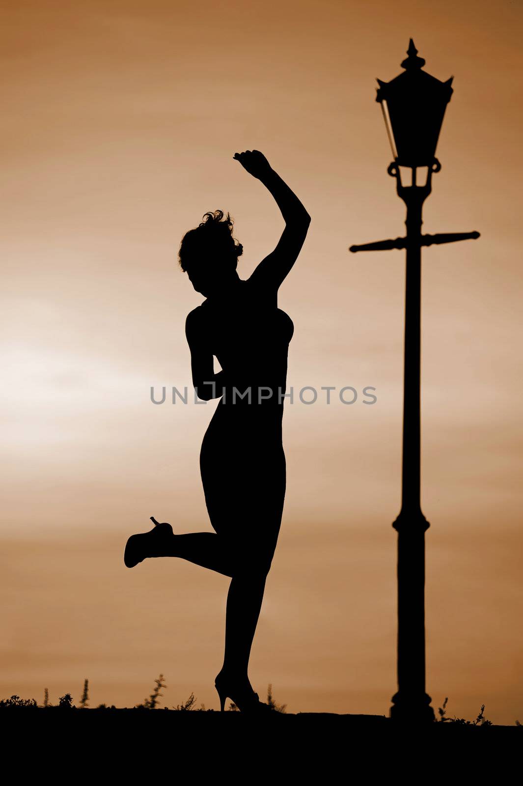 Silhouette of women dancing at sunset by lantern