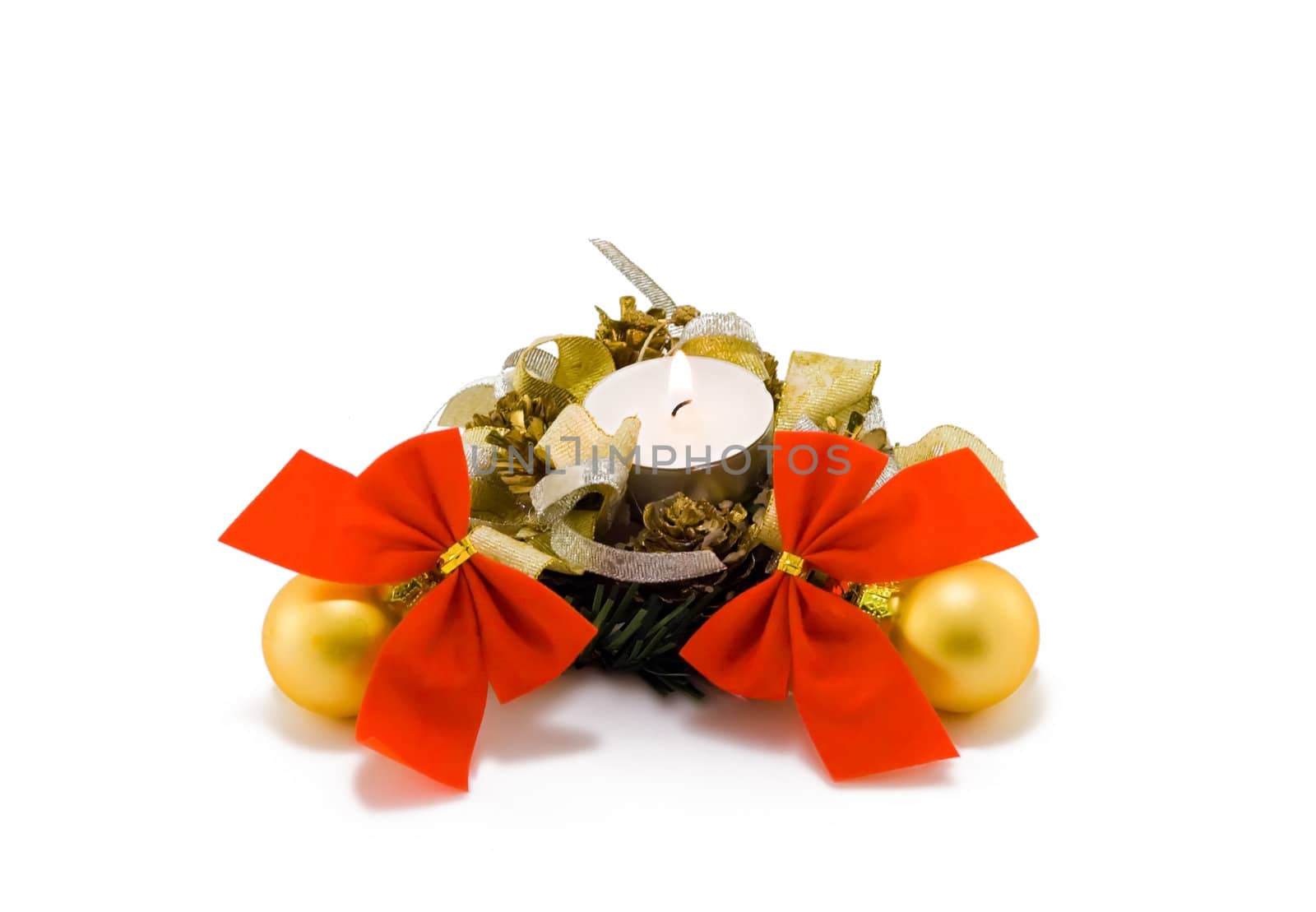 A christmas candle with yellow balls and red bows