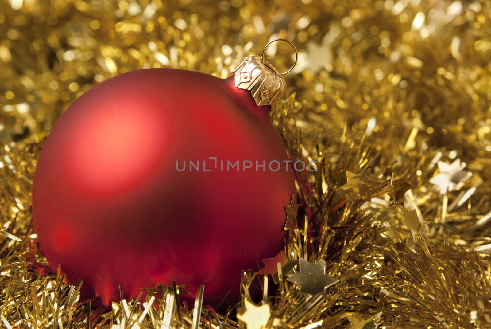 Red christmas ball on the gold tinsel. aRGB.