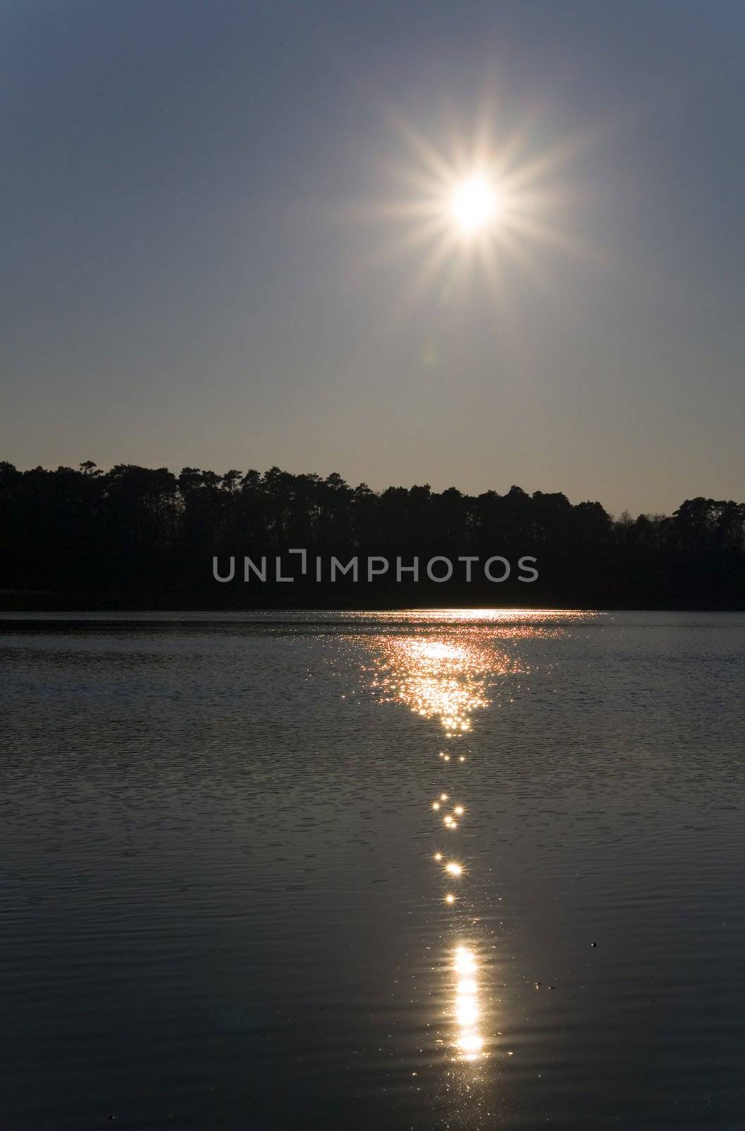 starry sun on the blue sky over the lake (Poland)