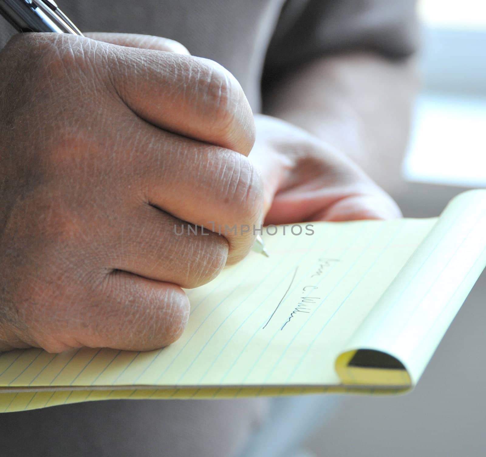 African american male taking notes at a meeting.