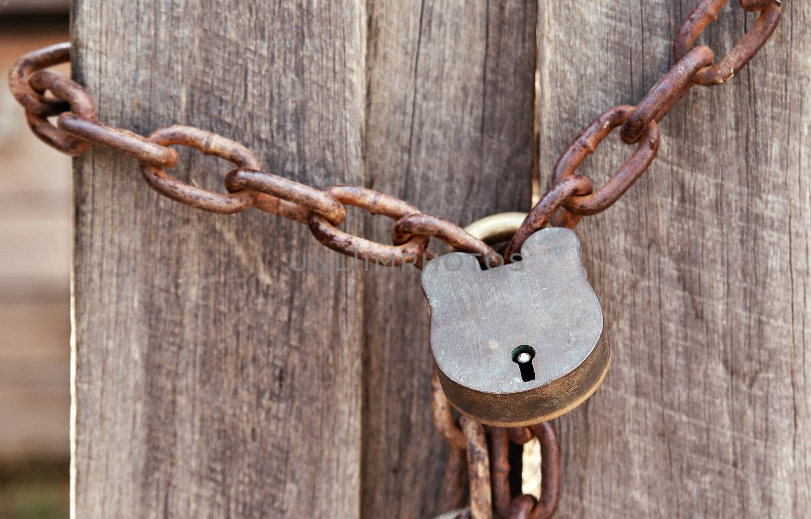 old lock and chain around wooden fence