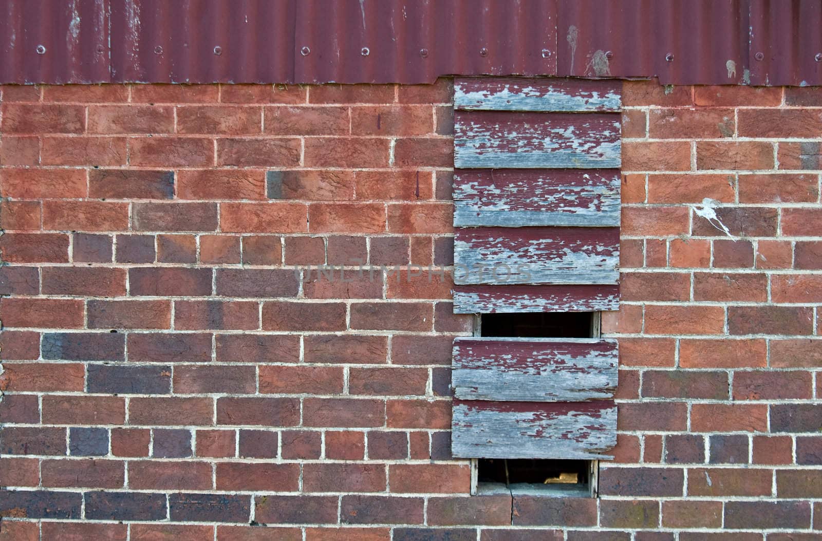 old red brick building with boarded up window