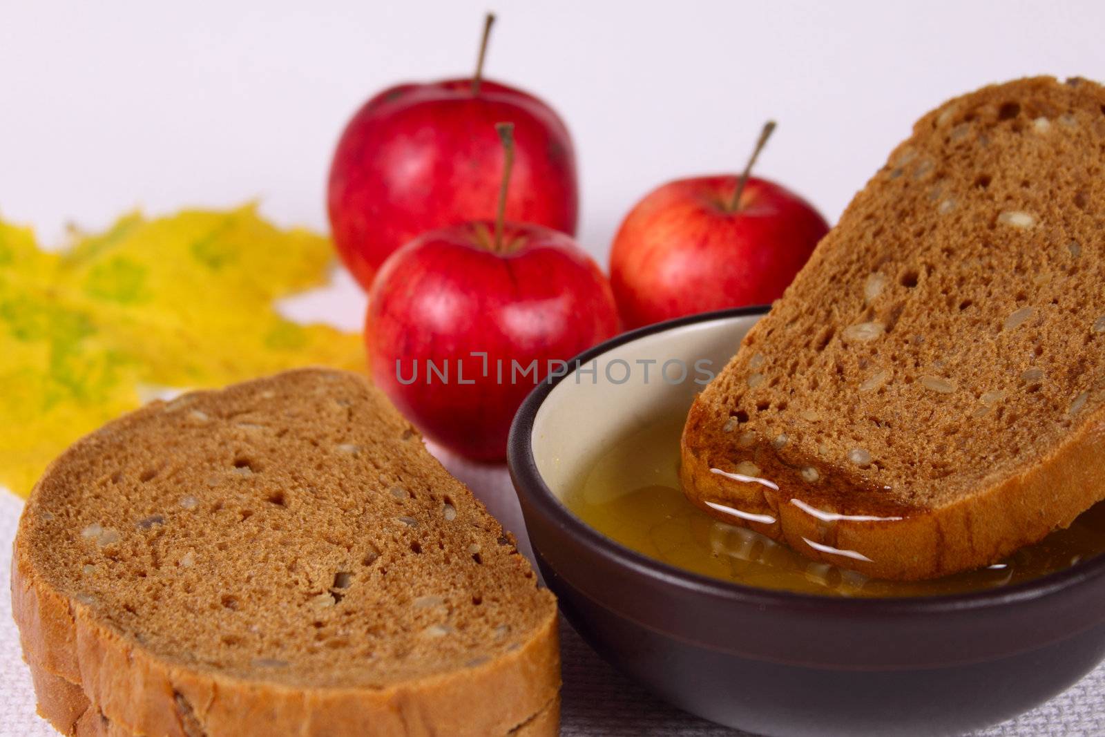 Bread, honey and apples removed close up on a linen napkin