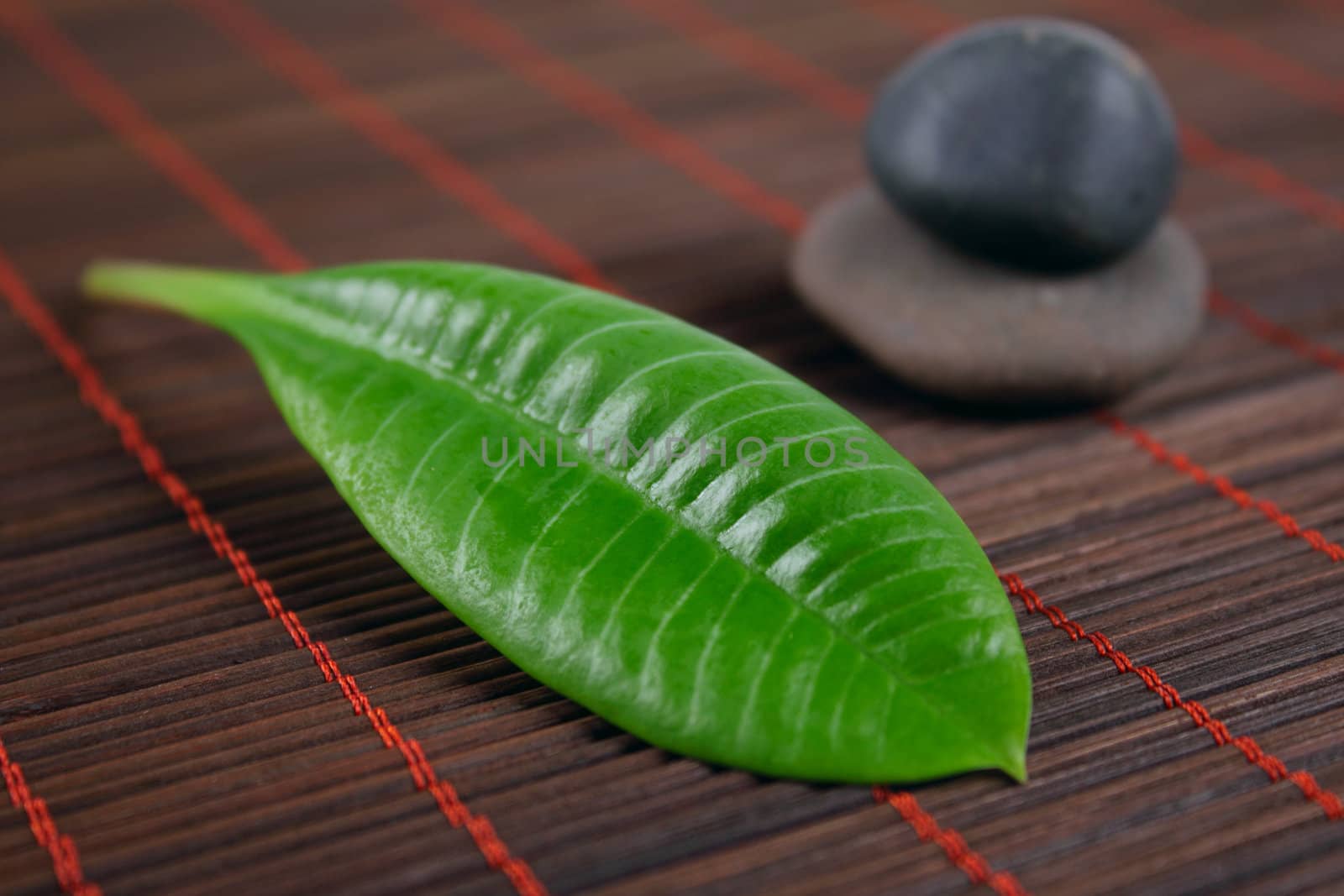 Stones for spa with green sheet on a bamboo napkin removed close up