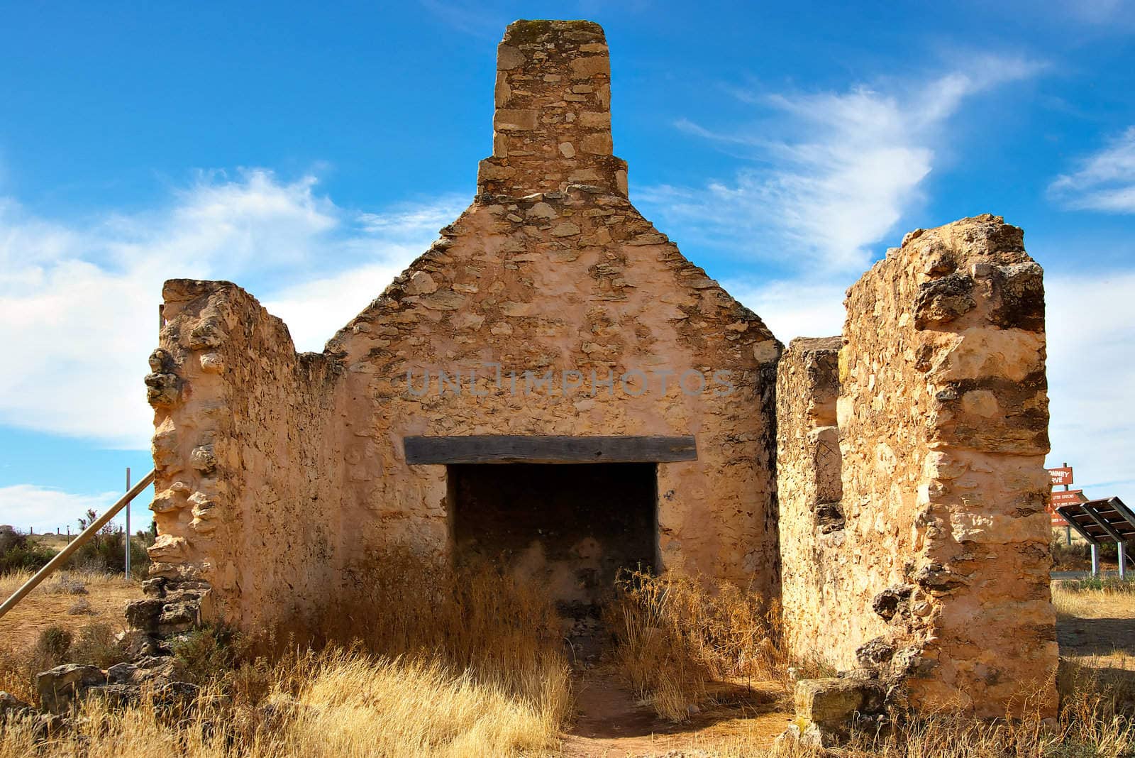 old ruins of a stone farmhouse full of weeds and rubble