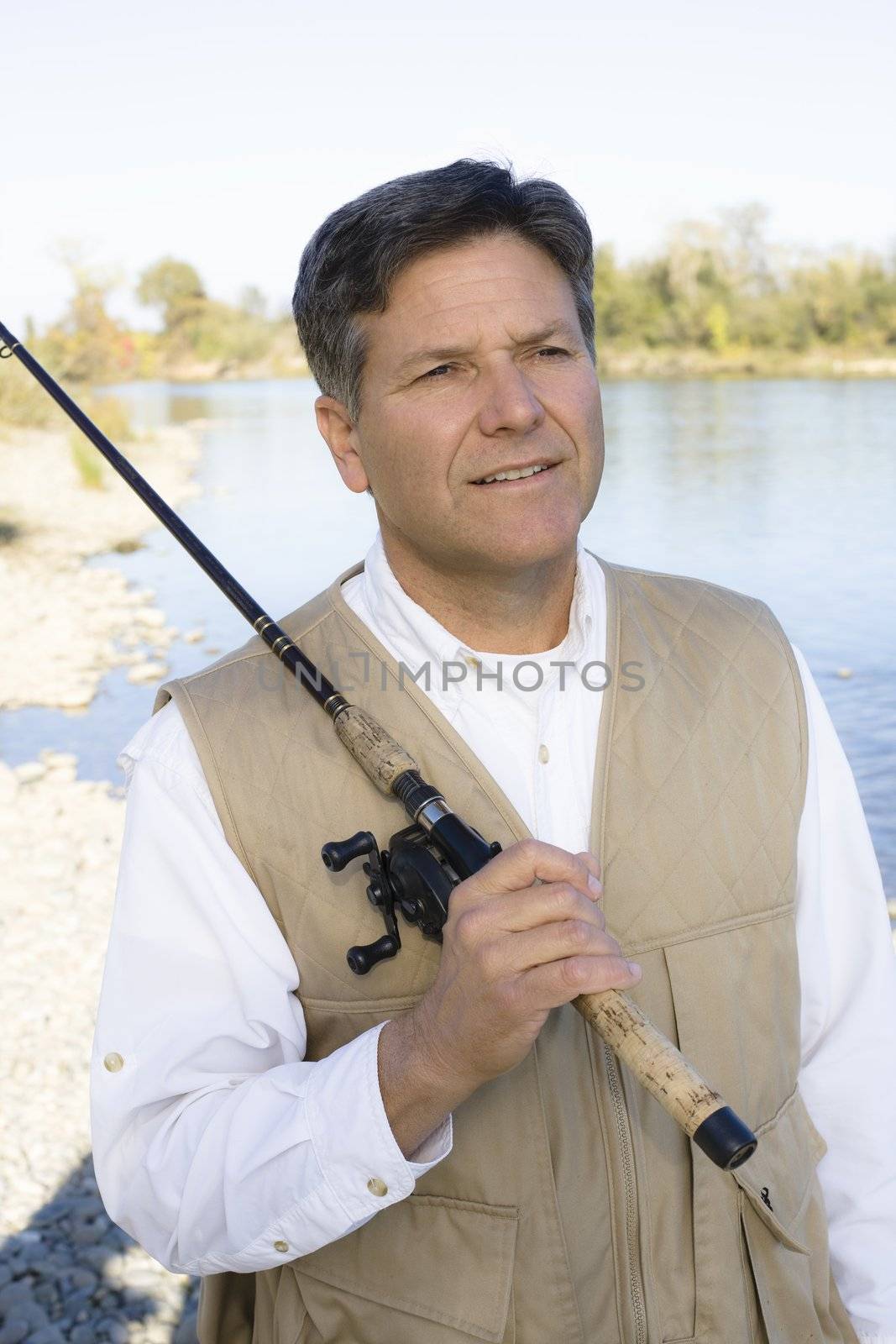 Man Standing By A River With A Fishing Pole