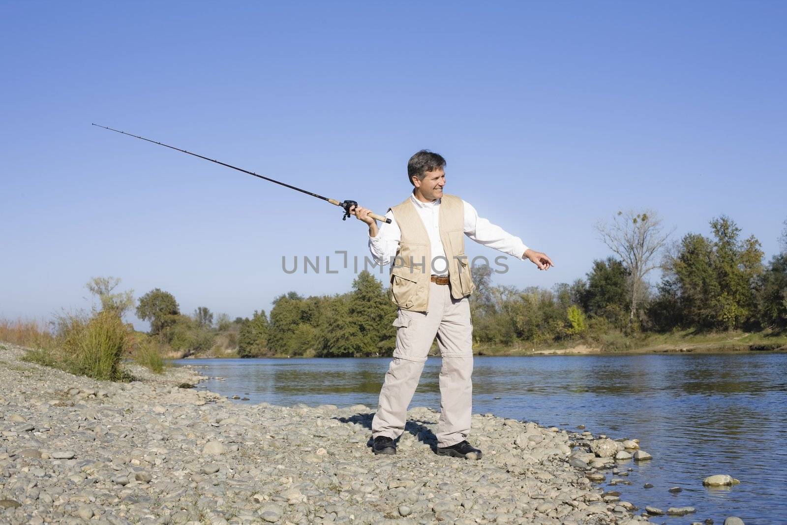 Man Standing By A River With A Fishing Pole