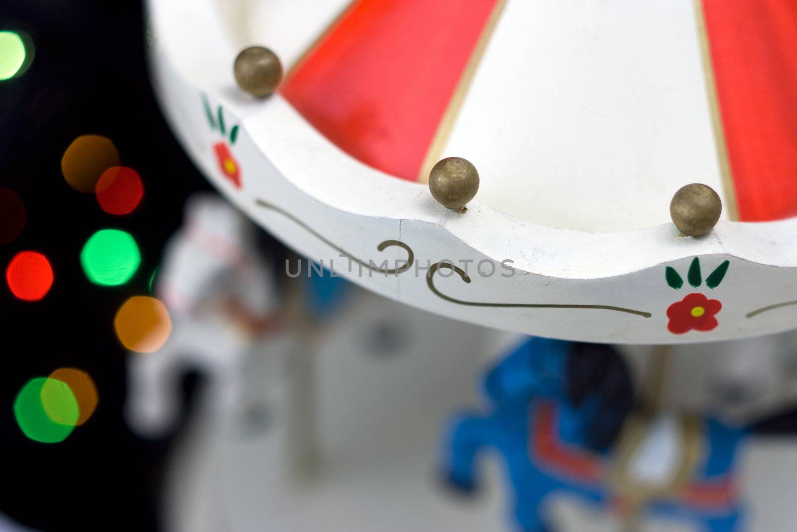 Miniature carousel with horses, against the background of New Year's lights. Depth of field for strong emotions.