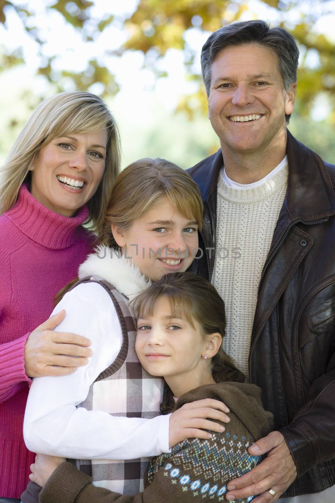 Portrait of a Happy Family of Four Standing in a Park