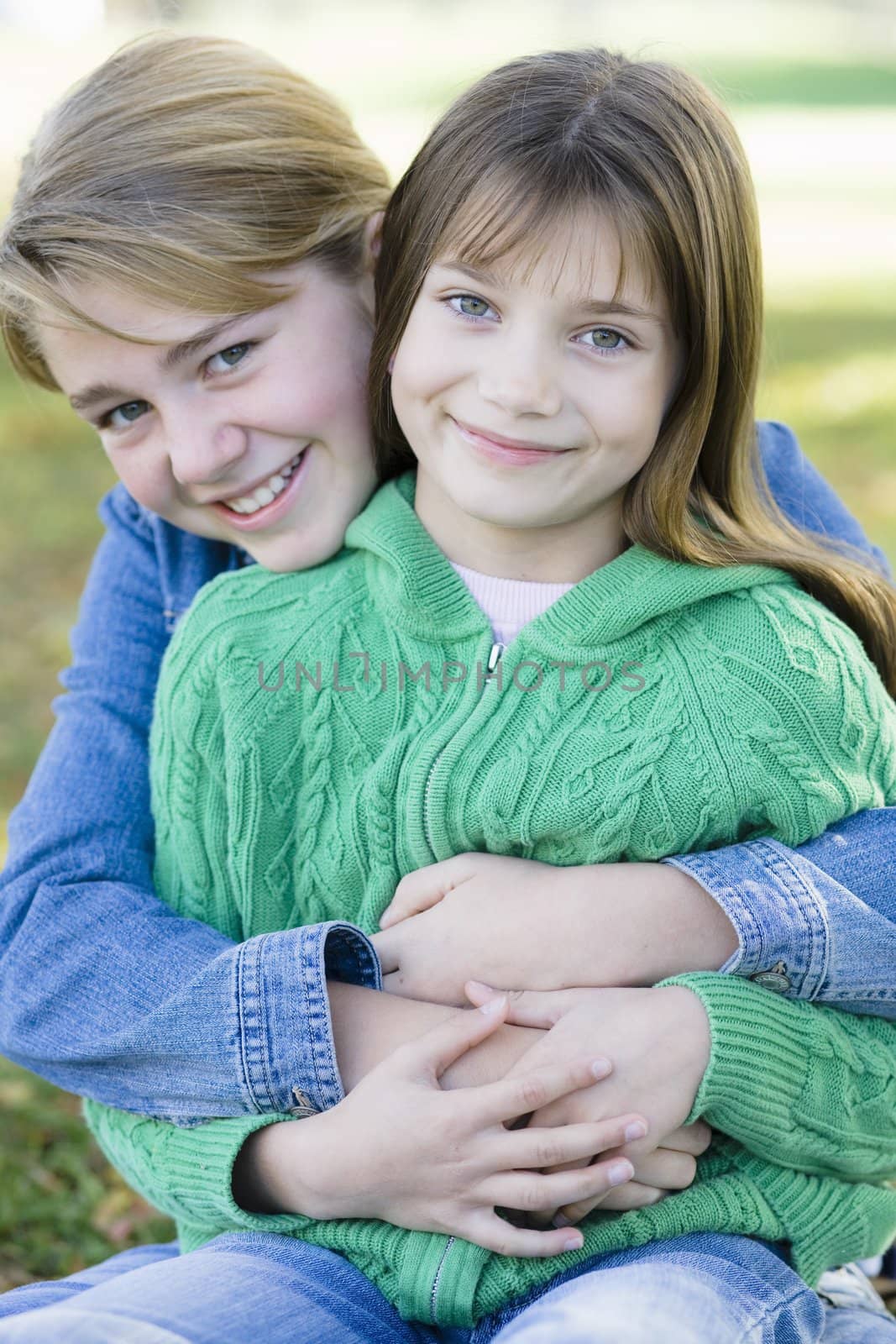 Portrait of Two Young Sisters Holding Each Other in a Park