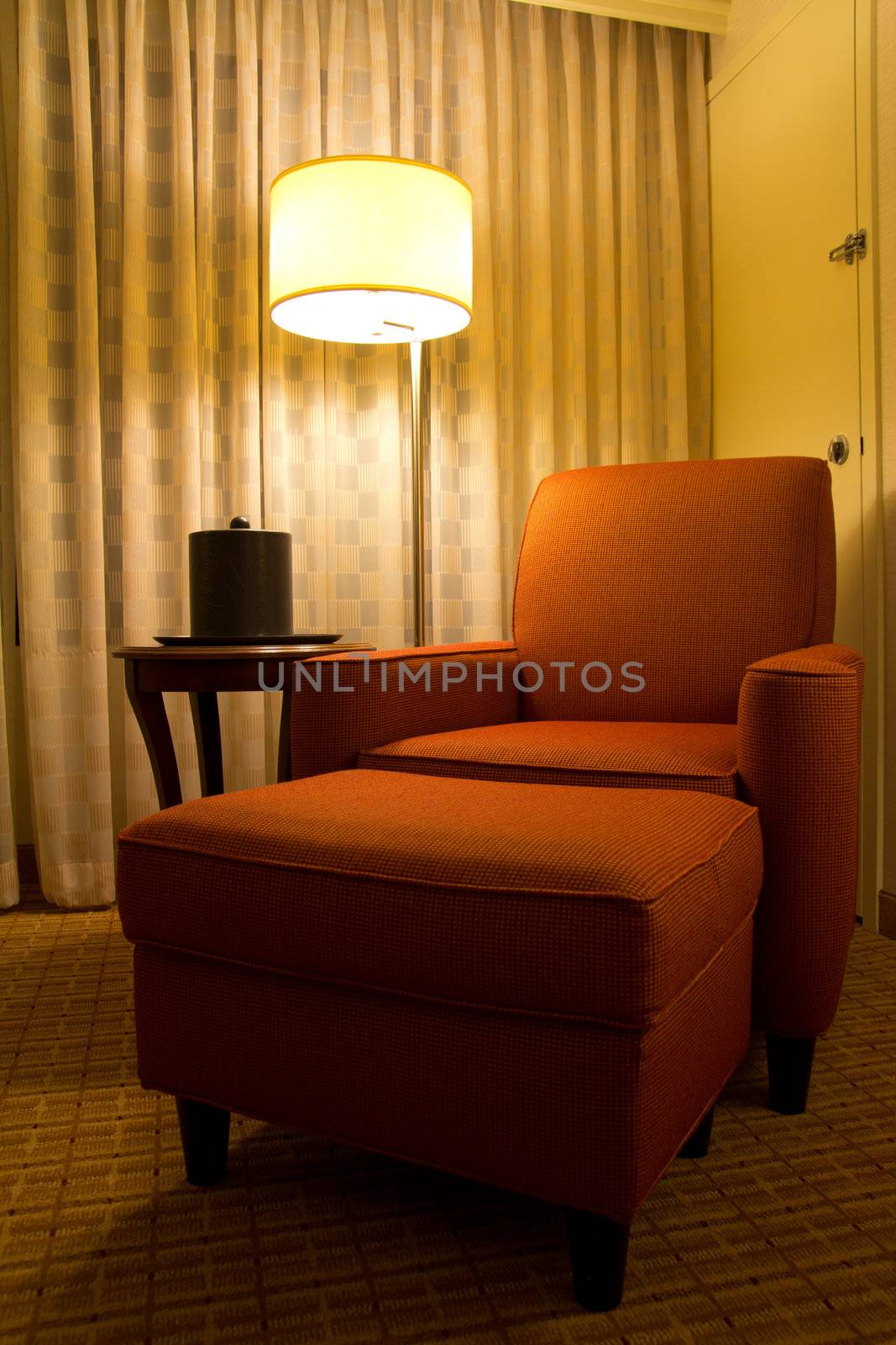 Relaxation chair in a corner of hotel room by Kenishirotie