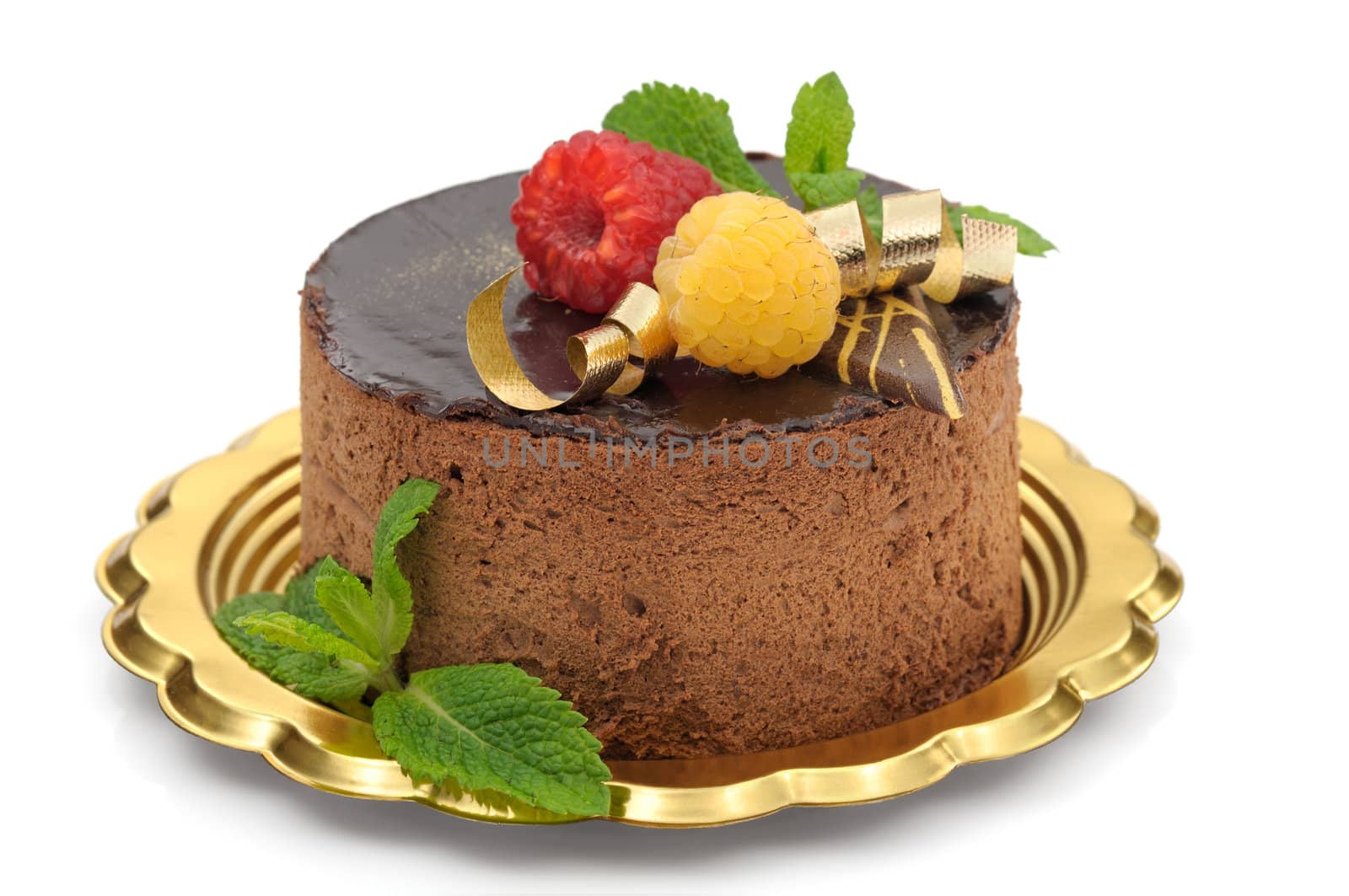 Chocolate mousse cake decorated with raspberries and mint leaves on white background