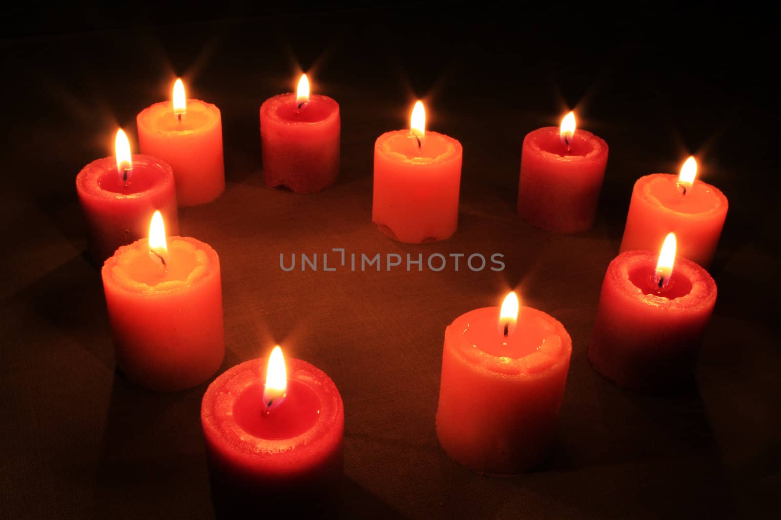 Some candles in heart-shaped composition on linen background