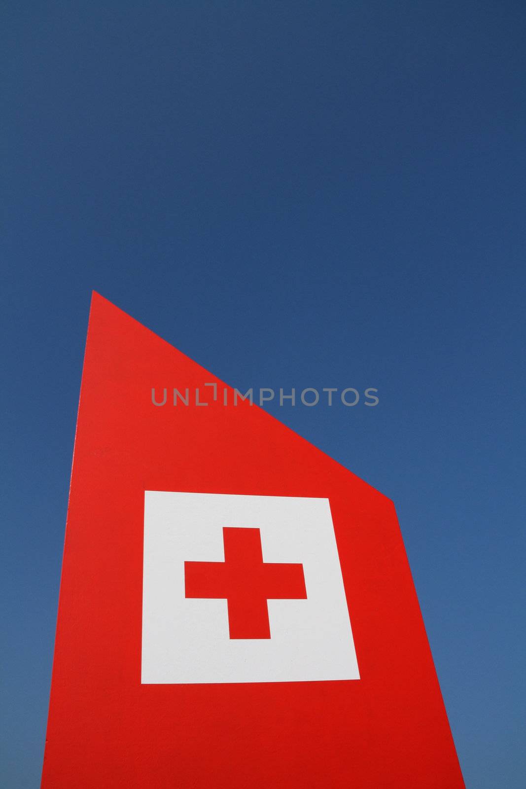a red cross signal on a clean blue sky background
