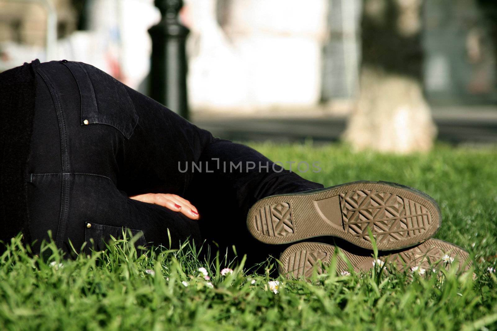 a woman resting and sleeping on the grass at a park
