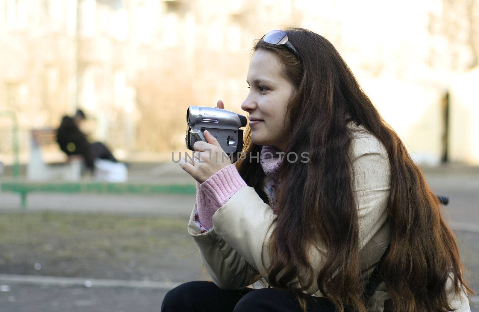 Young woman with videocamera
