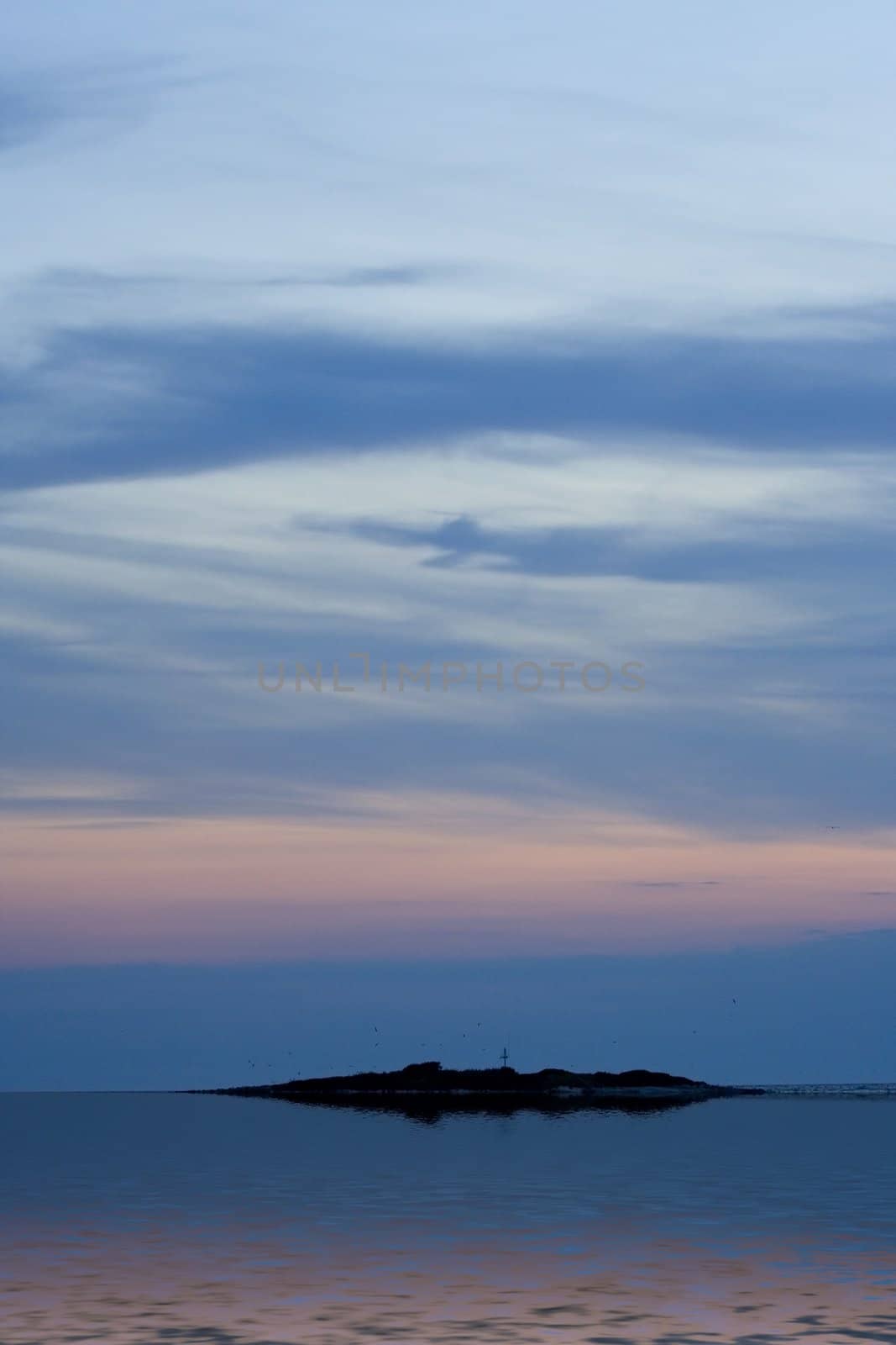 Island below sunet sky with reflection
