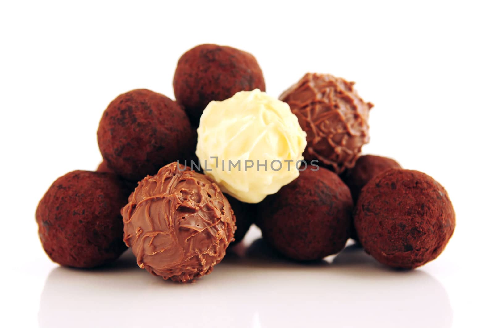 Pile of assorted chocolate truffles isolated on white background