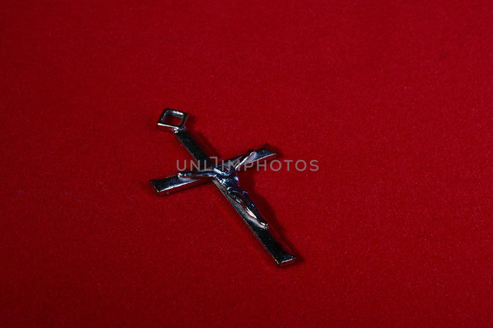 Catholic cross without a chain on a red velvet.