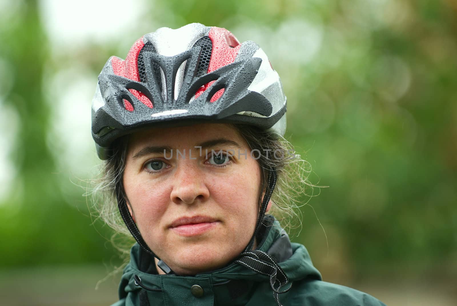 Woman out on a bike trail with her helmet on. 