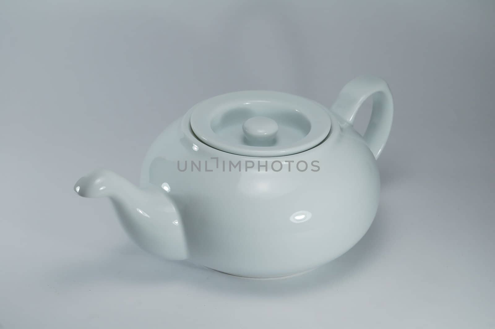 white porcelain tea-pot on a light background, studio illumination