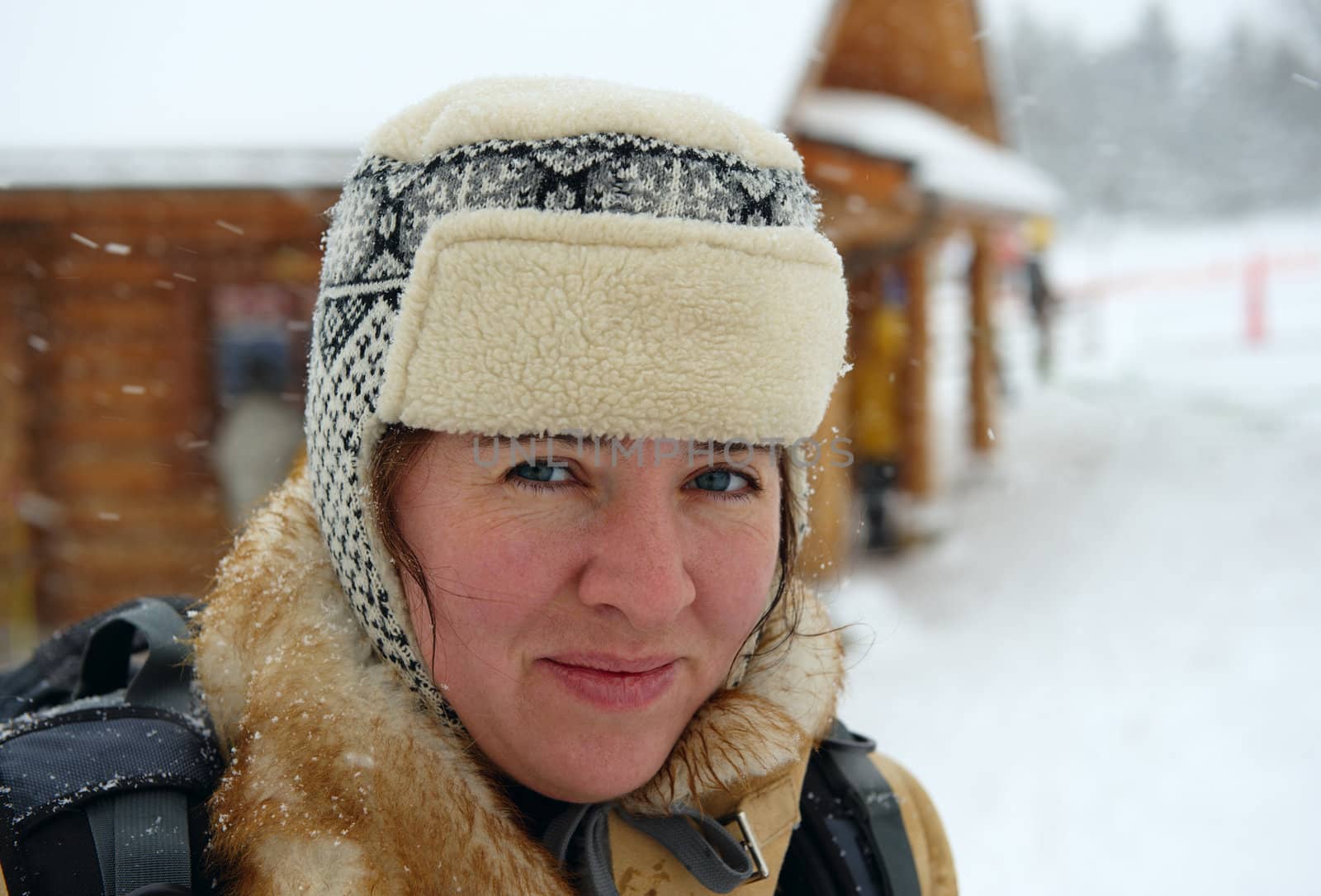 Portrait of the woman on a winter vacation in mountains during a snowfall