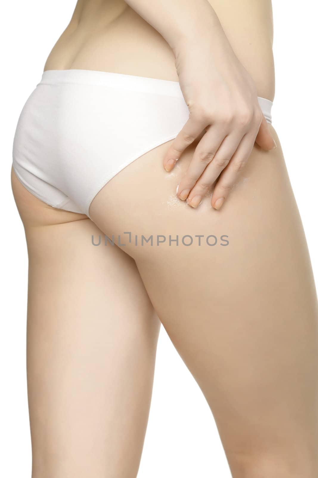 Woman applying moisturizer cream on legs, isolated on white background