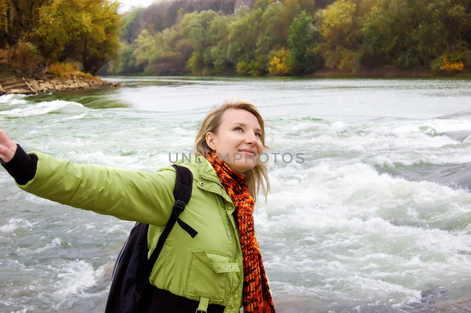 Young woman feeling free over late river autumn background
