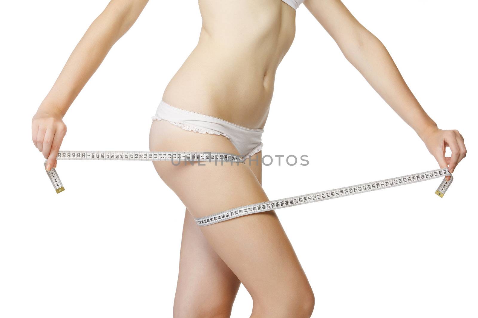 Woman measuring her thigh with a white metric tape, isolated on white background