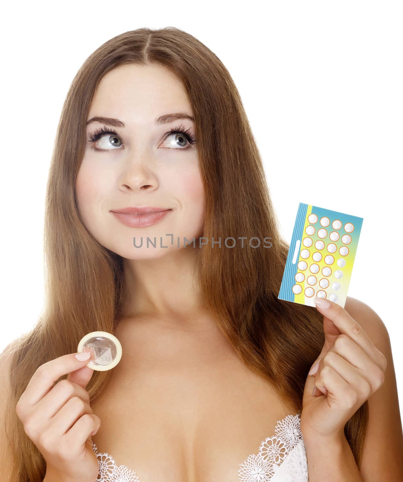 Pretty girl with condom and contraceptive pills. Isolated over a white background
