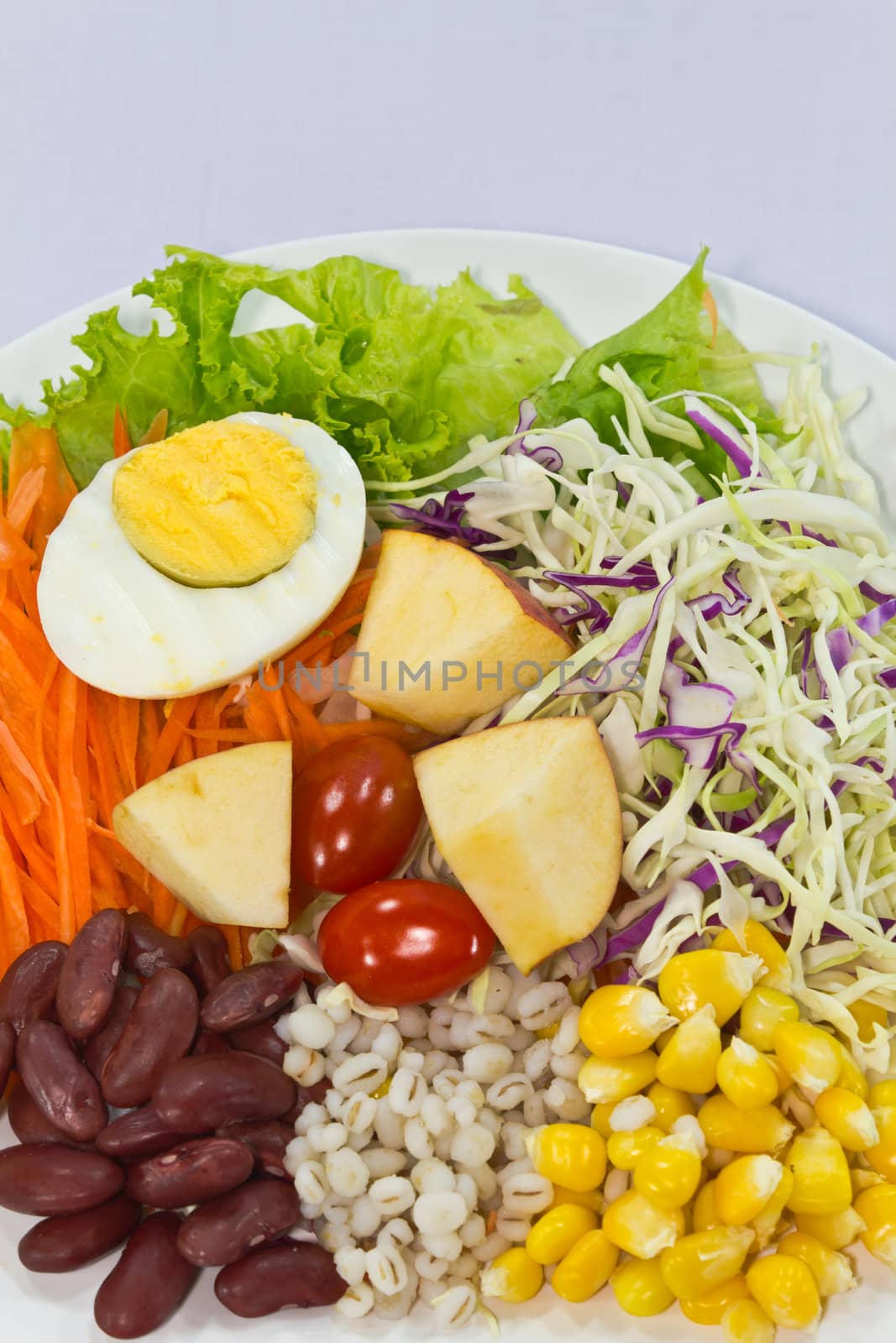 Fruit salad with boiled egg on a white plate