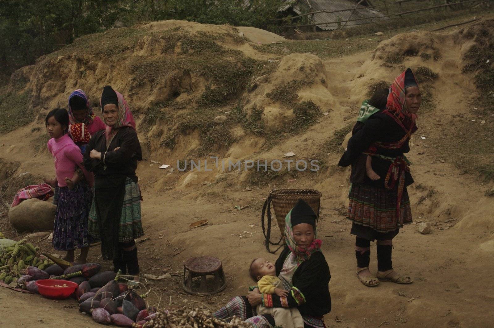Along the road in front of the village women Phu La ethnic group sell their meager crops